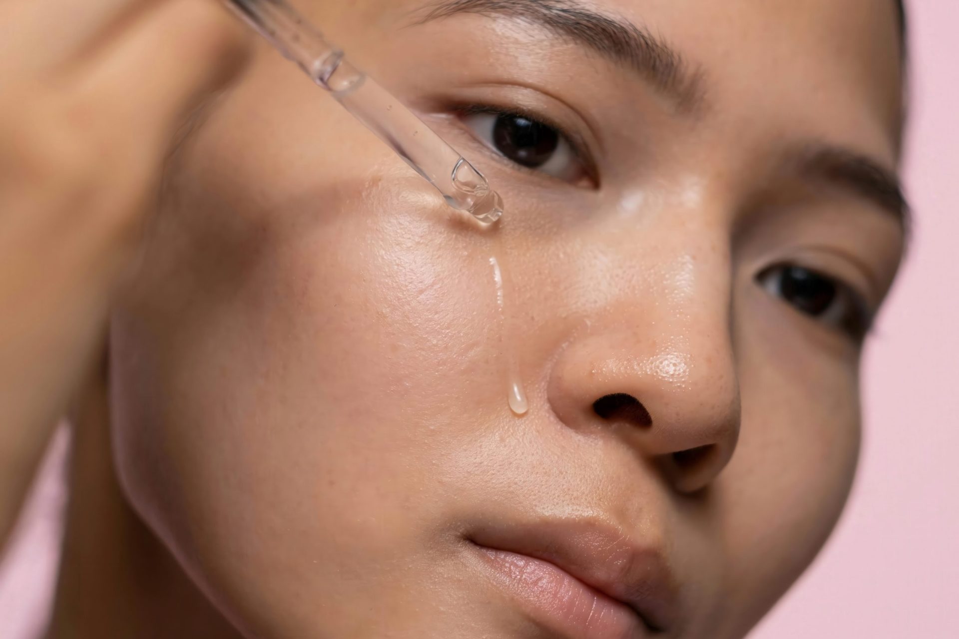 woman applying serum to her face